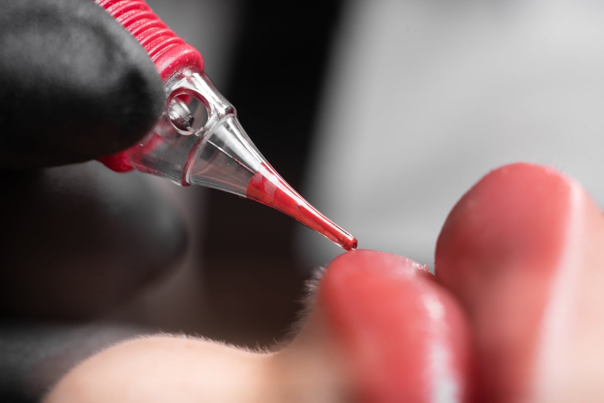 process of applying a permanent makeup tattoo to the lips in a beauty salon, close-up, female lips with a coloring pigment, lip tattooing in a clinic